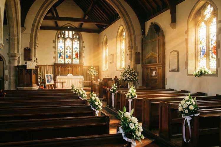 Memorial Services in Tunbridge Wells : Interior of a traditional church chapel set up for a memorial service, with flowers, chairs arranged in rows, and warm natural light streaming through windows.
