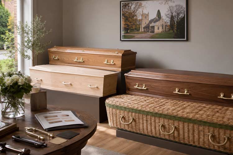 Coffin supplier in Chislehurst and Bromley showing traditional wooden coffins and a willow coffin in a calm funeral home.