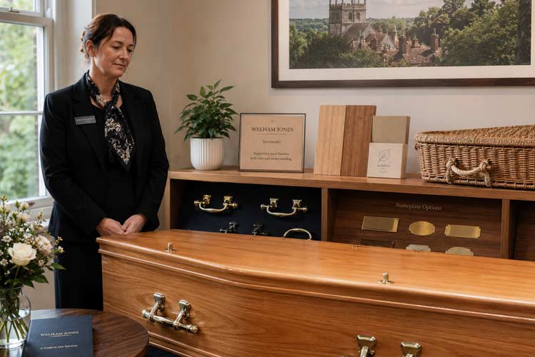 Coffin supplier in Sevenoaks with wooden coffins, nameplate options and a funeral arranger in a respectful showroom setting.