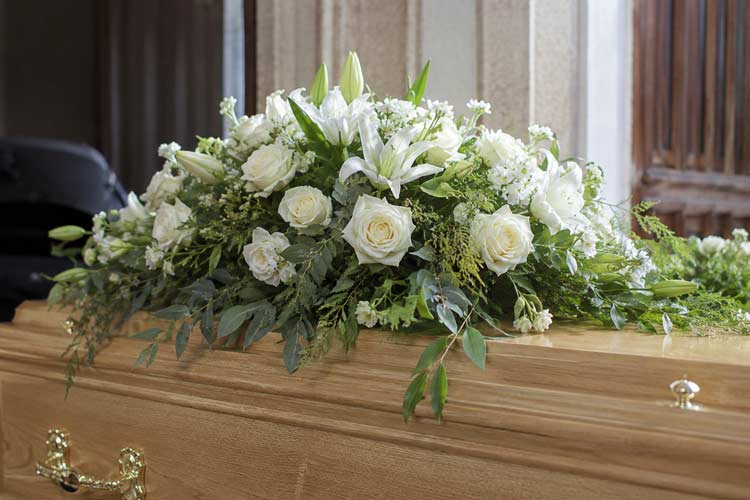 White funeral flower tribute with roses, lilies and greenery for florist services in Swanley.